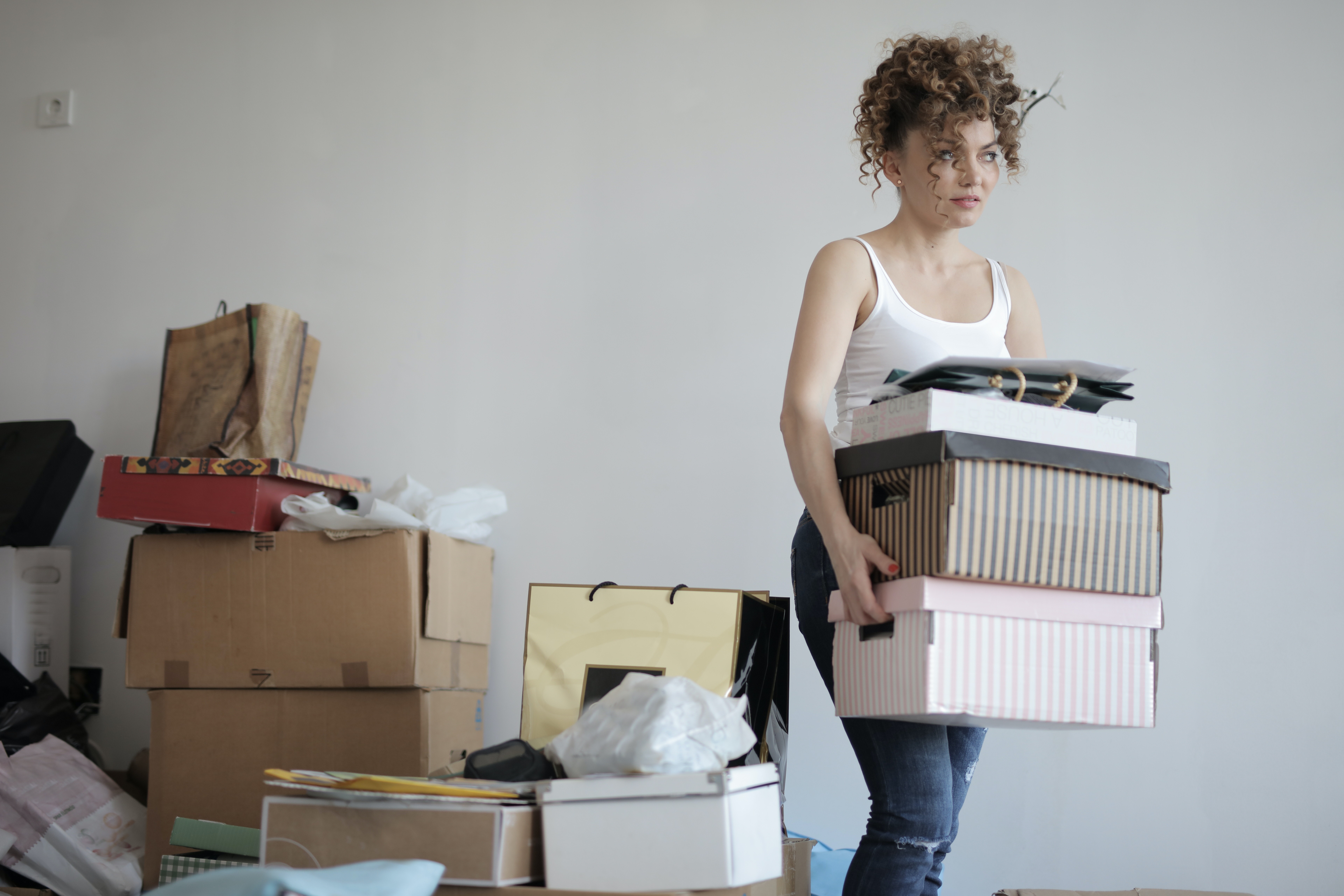 woman moving boxes, curly hair. Decluttering