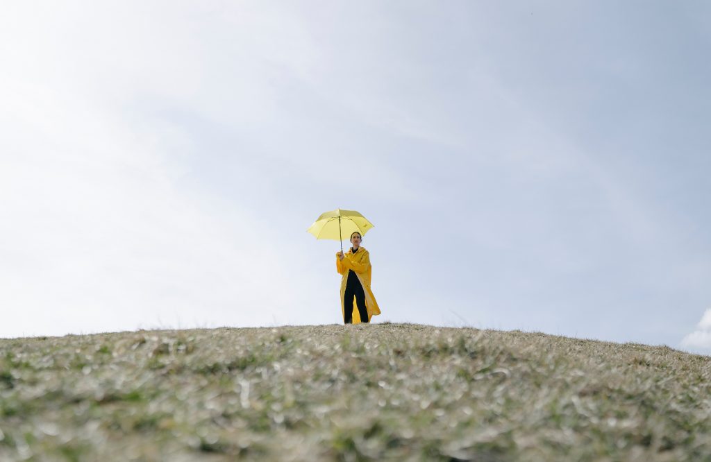 Where To Turn When You've Lost Your Way. Woman in yellow coat and umbrella. 