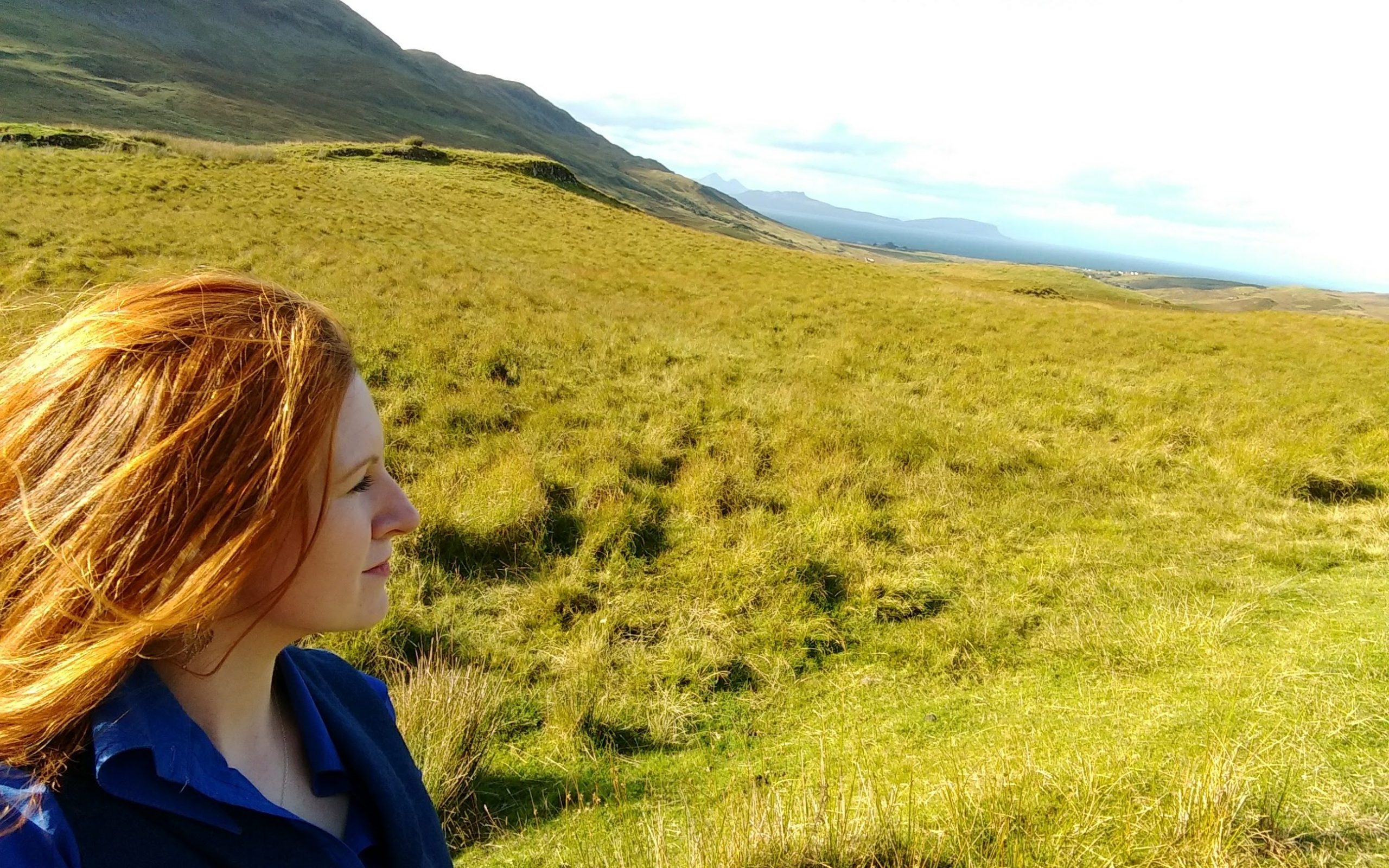 claire gillies author looking out over hills. highland lass, red hair, looking over hills and sea. From Scotland with Love - My Love Letter to Home